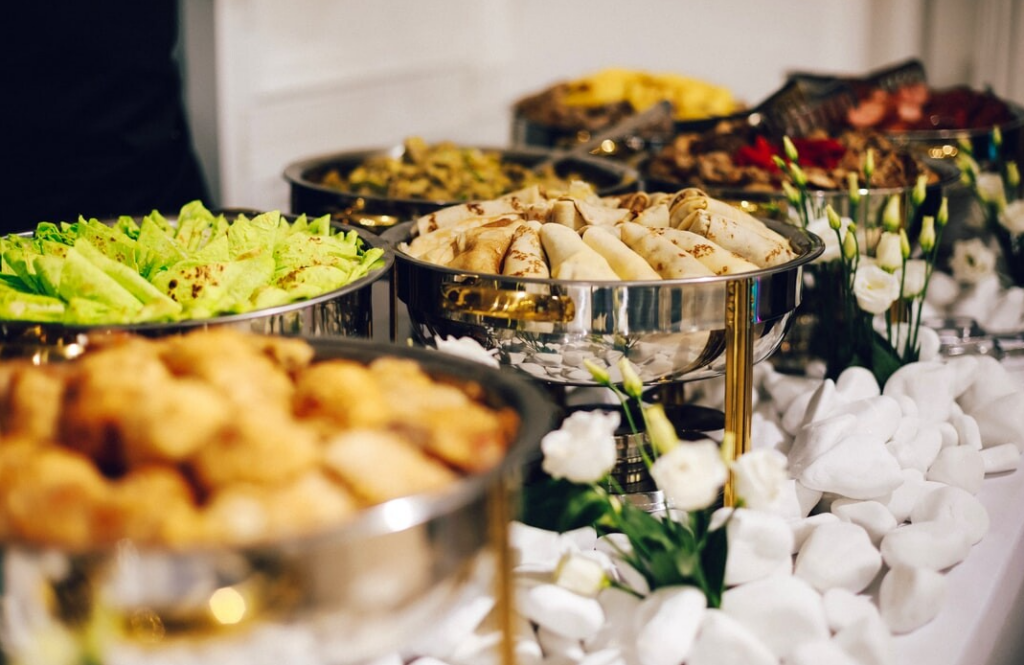 Office catering buffet with salads, appetizers, and chafing dishes