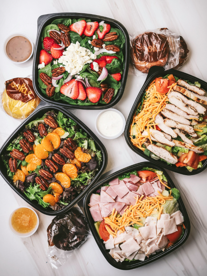 Individually portioned meal prep trays with chicken, salmon, rice, and vegetables for a recurring meal program