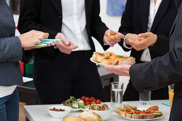 Corporate event guest holding a plate of catered hors d'oeuvres